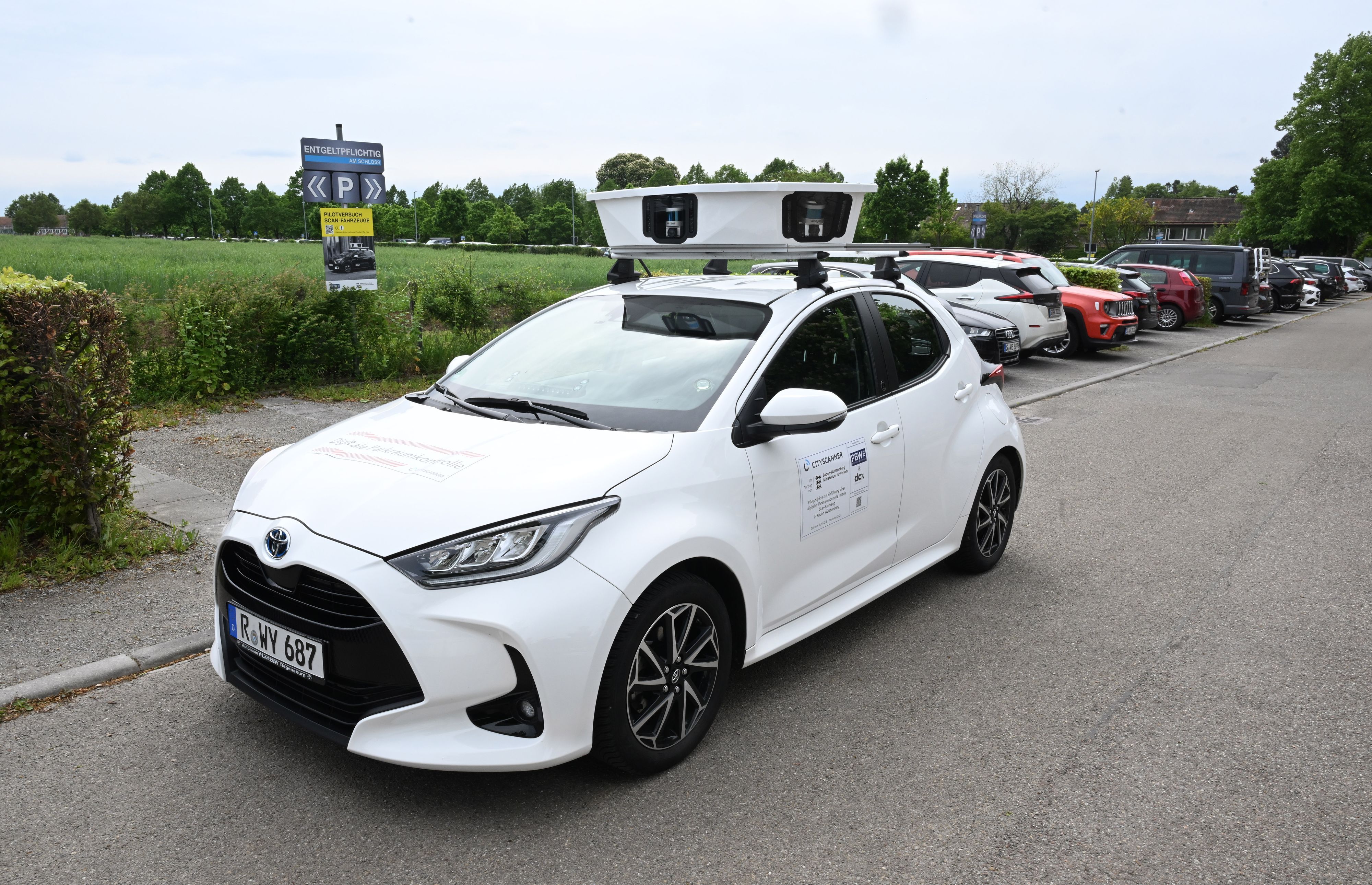 Ein Scan-Auto, das automatisch Parksünder registriert, fährt an geparkten Fahrzeugen vorbei.