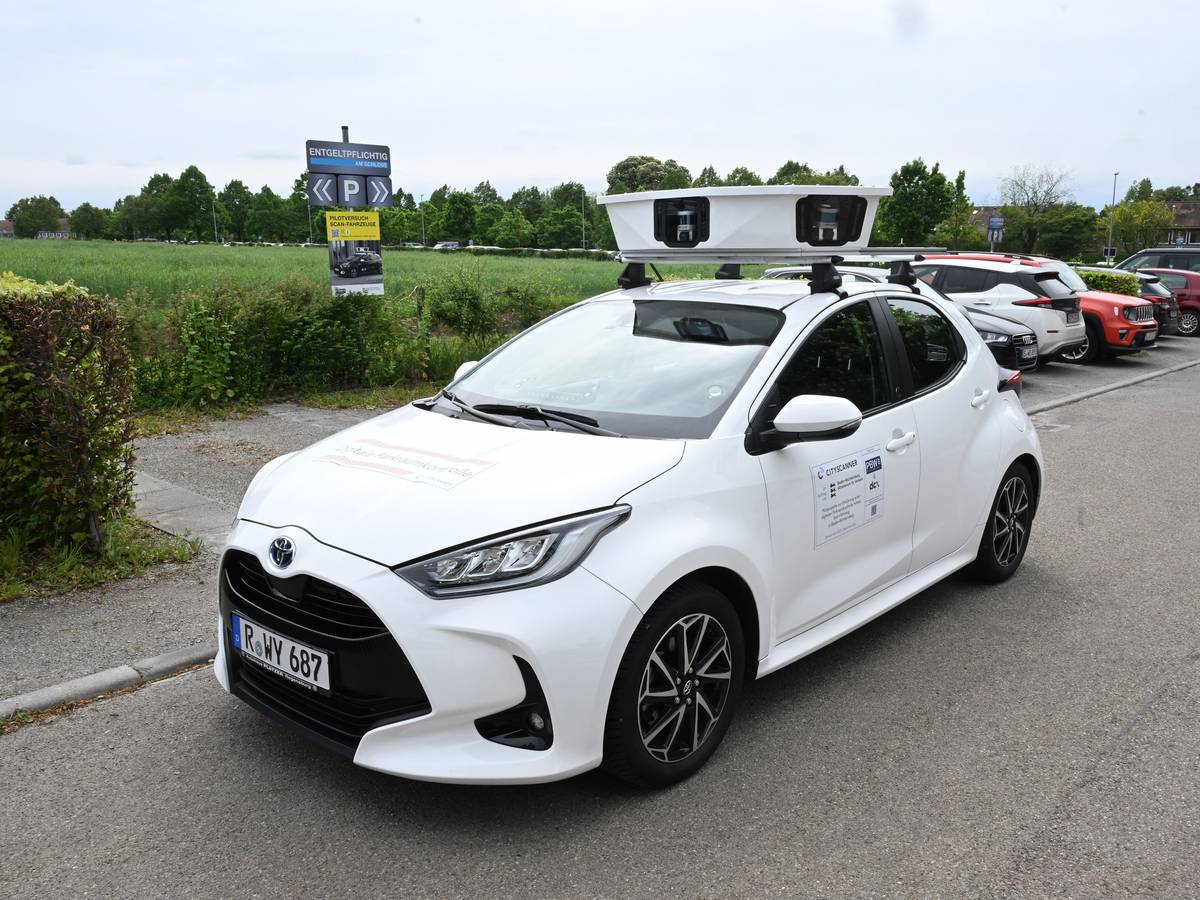 Ein Scan-Auto, das automatisch Parksünder registriert, fährt an geparkten Fahrzeugen vorbei.
