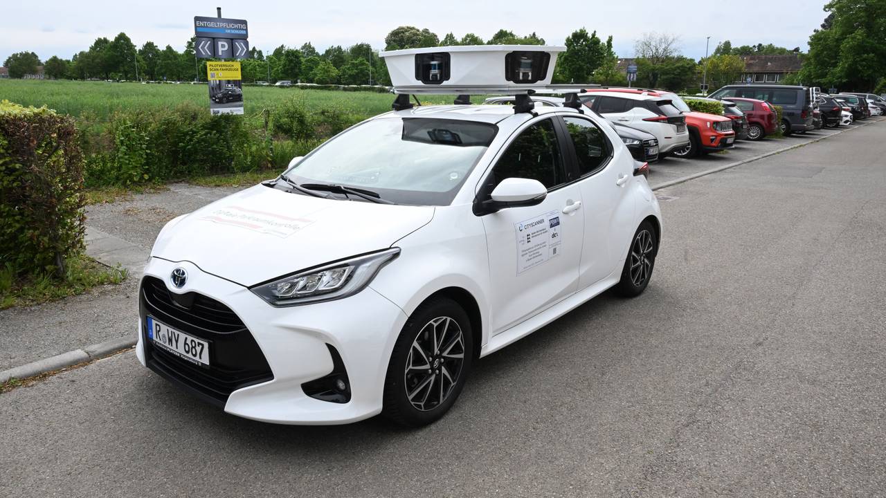 Ein Scan-Auto, das automatisch Parksünder registriert, fährt an geparkten Fahrzeugen vorbei.