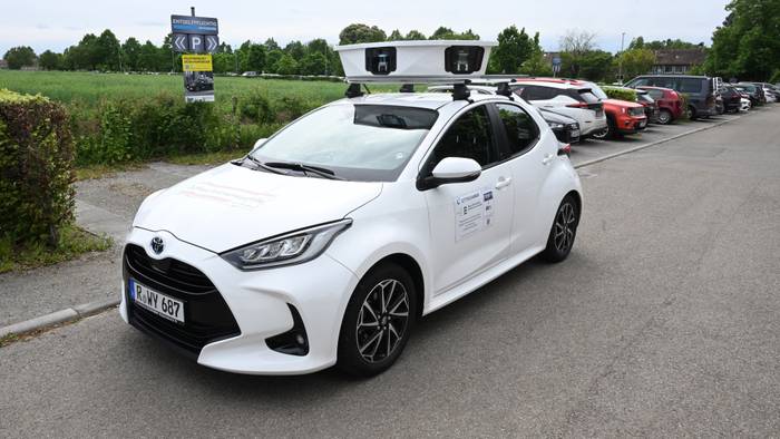 Ein Scan-Auto, das automatisch Parksünder registriert, fährt an geparkten Fahrzeugen vorbei.