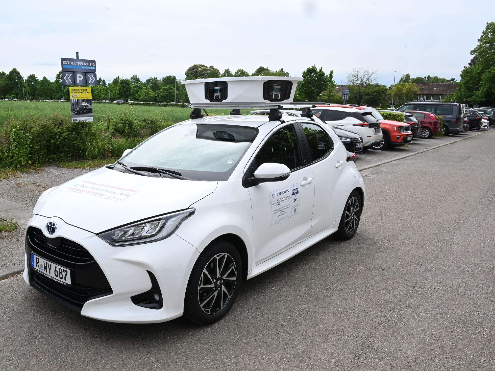 Ein Scan-Auto, das automatisch Parksünder registriert, fährt an geparkten Fahrzeugen vorbei.