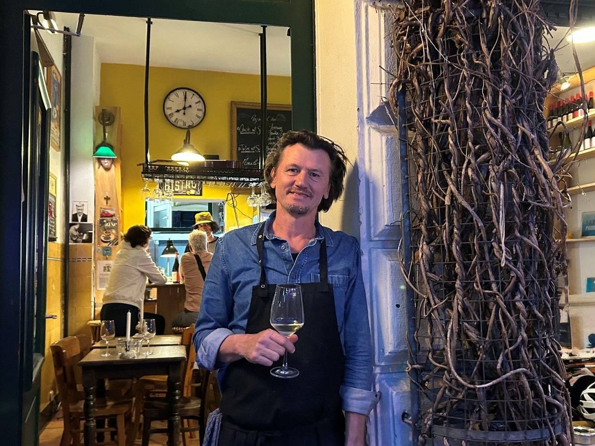 David Boucherie steht mit einem Glas Wein in der Tür seines Lokals.