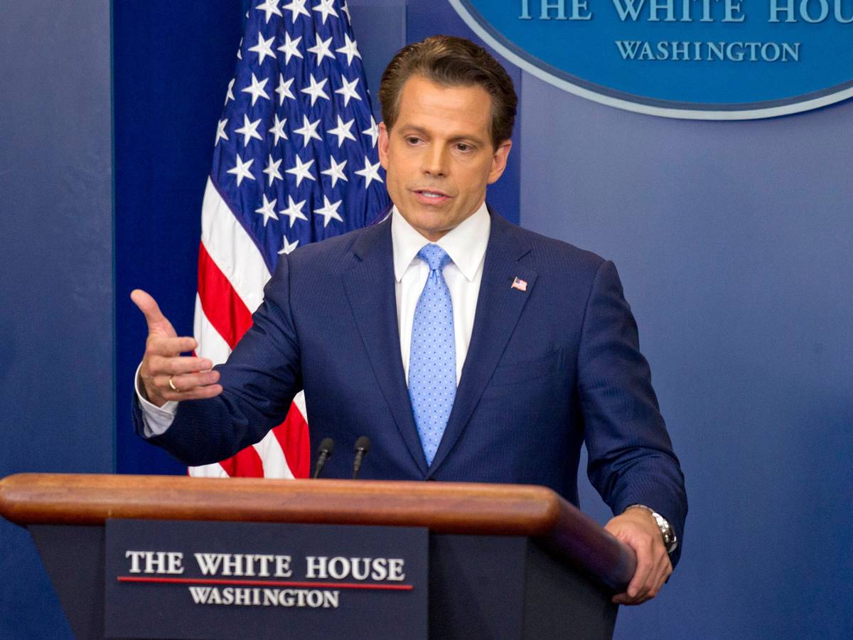 Anthony Scaramucci spricht am Rednerpult mit Flagge im Hintergrund