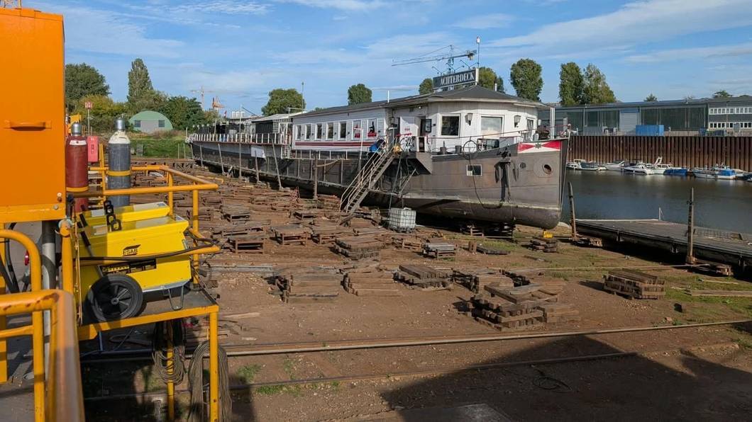 Ein Kran steht neben einem Bootshaus.