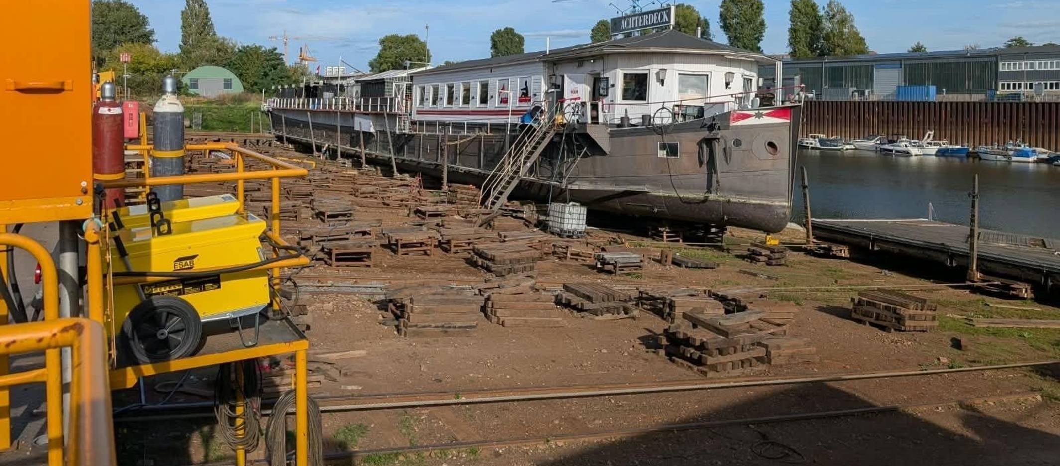 Ein Kran steht neben einem Bootshaus.