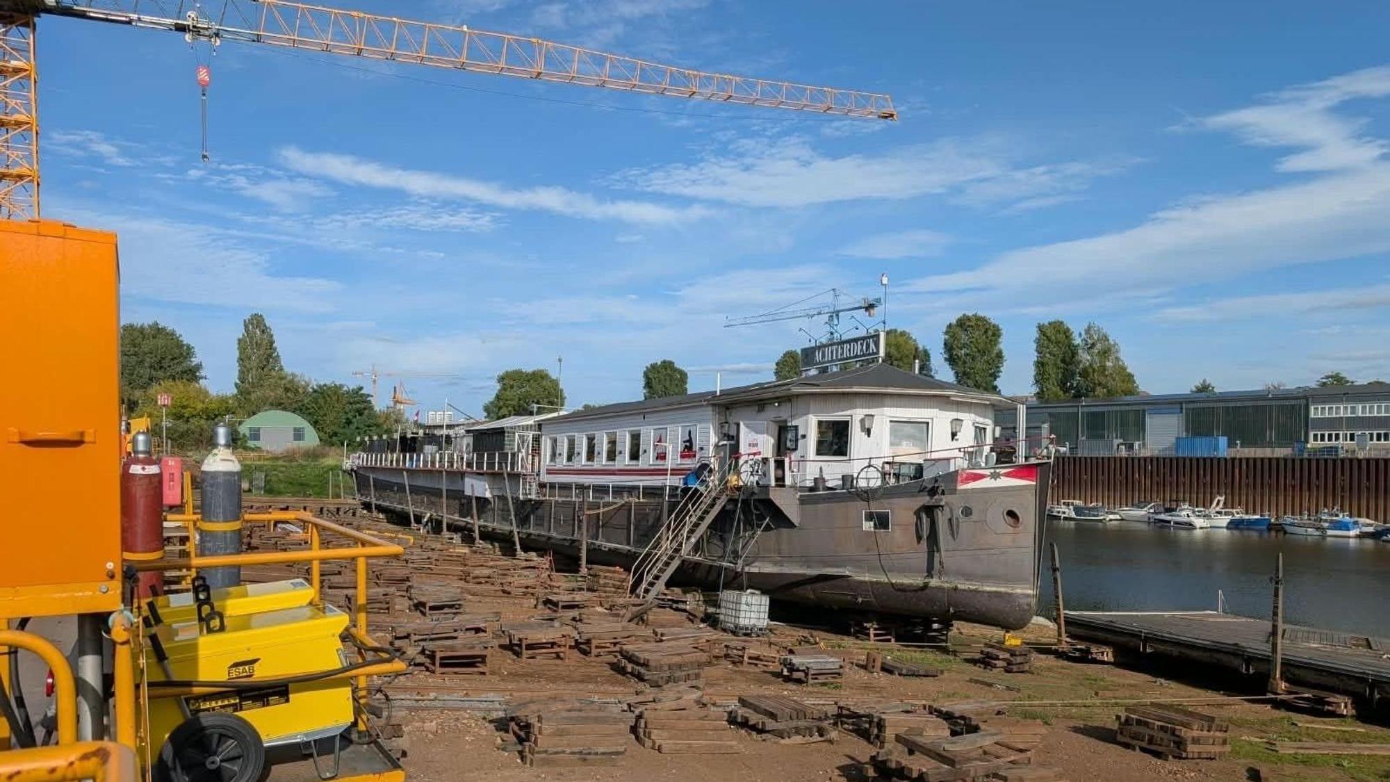 Ein Kran steht neben einem Bootshaus.