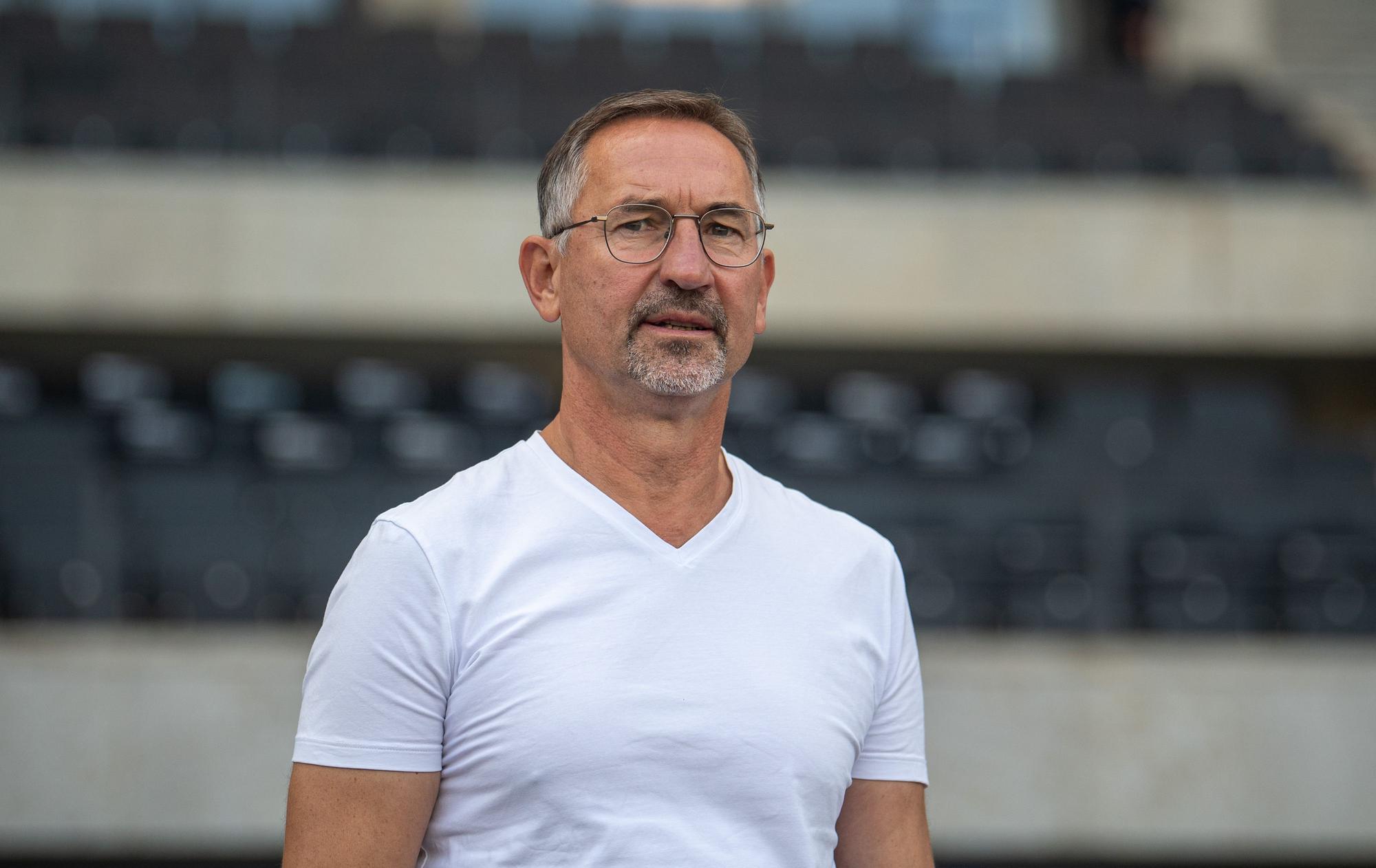 Achim Beierlorzer in weißem T-Shirt.