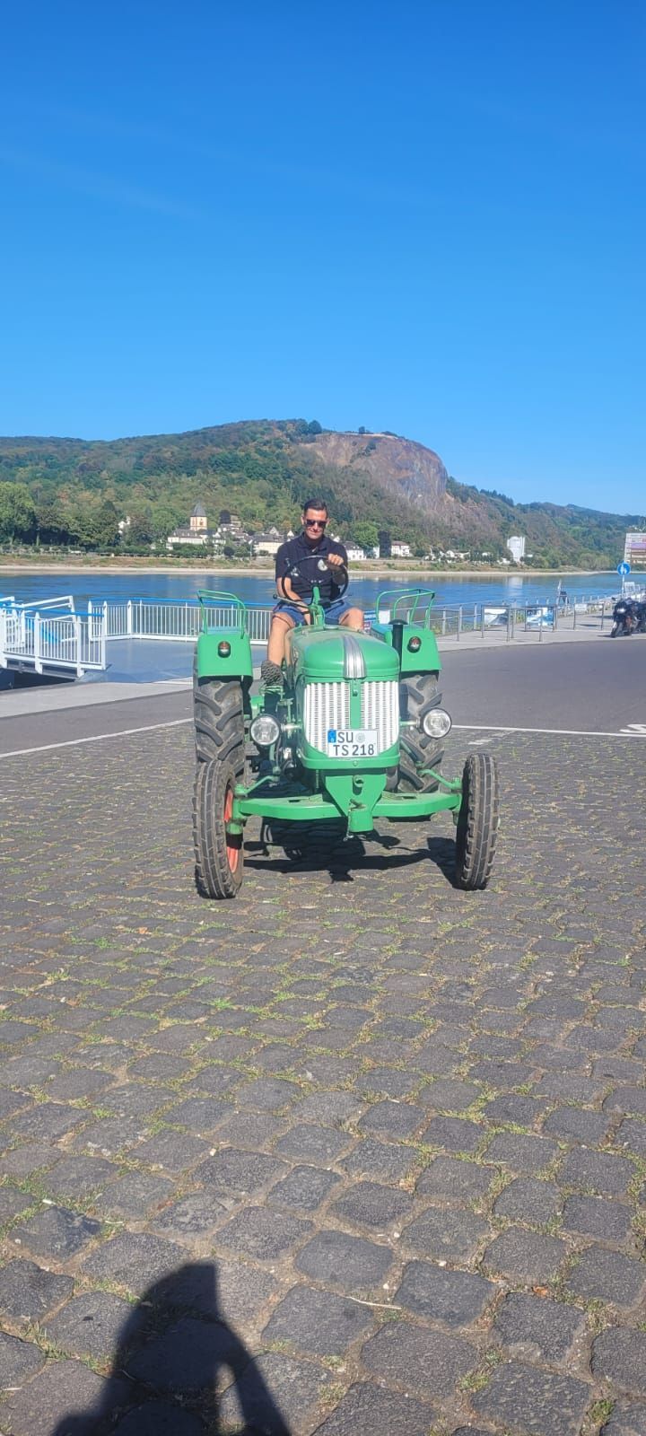 Tobias Schmitz sitzt auf seinem Trecker am Rheinufer.