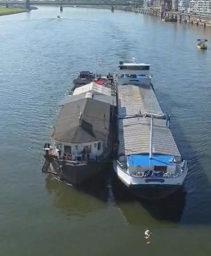 Zwei Schiffe fahren eng nebeneinander auf dem Rhein.