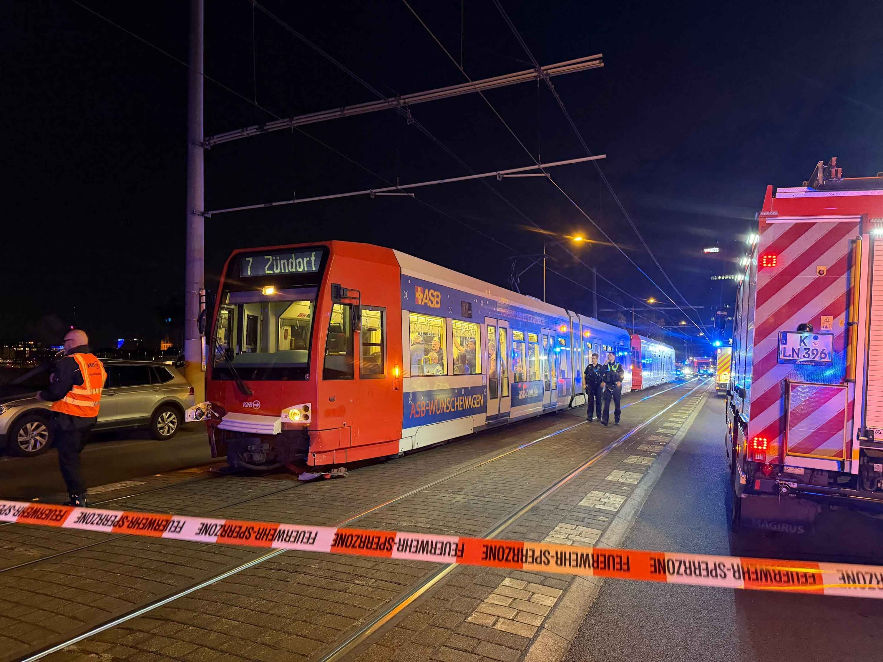 Die Polizei hat eine Unfallstelle in Köln mit Flatterband abgesperrt, davor steht eine Bahn der Linie 7.