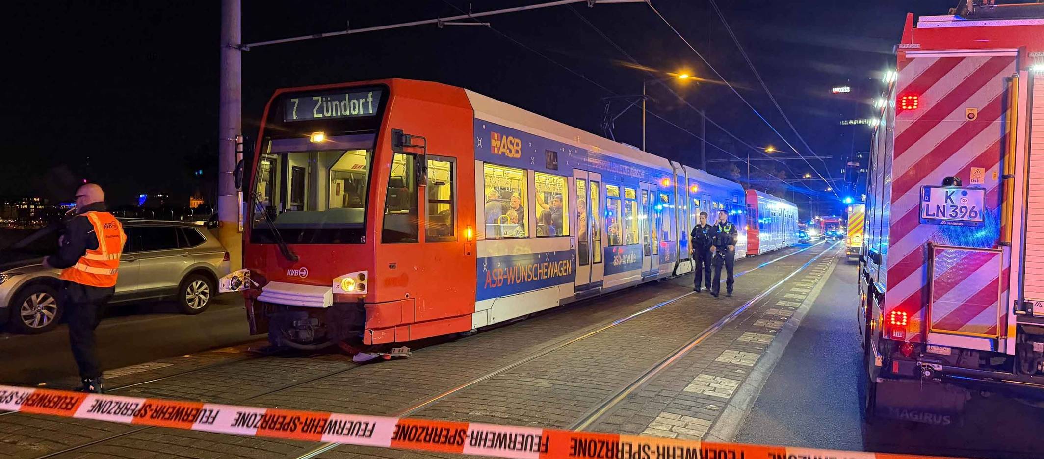 Die Polizei hat eine Unfallstelle in Köln mit Flatterband abgesperrt, davor steht eine Bahn der Linie 7.
