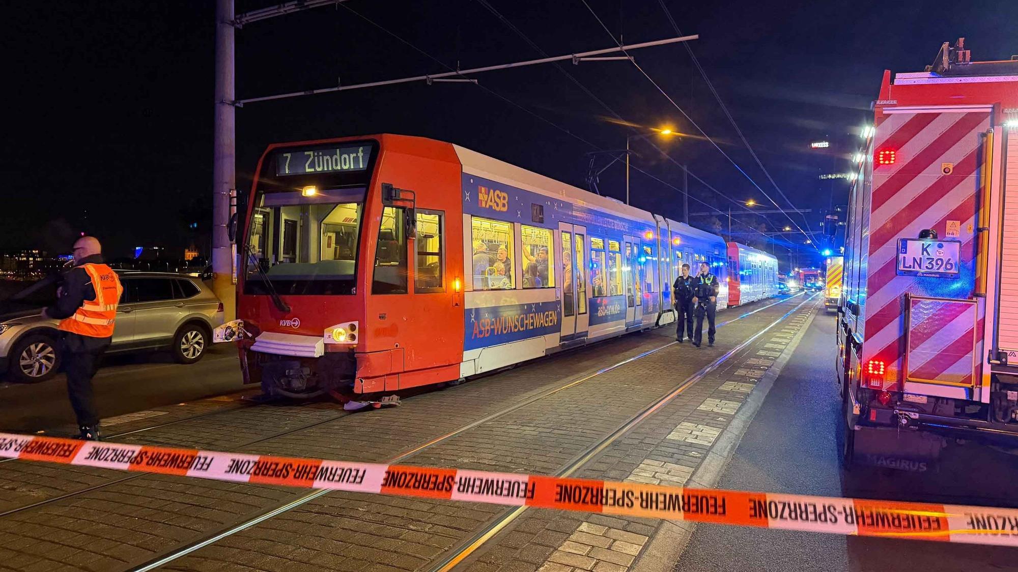 Die Polizei hat eine Unfallstelle in Köln mit Flatterband abgesperrt, davor steht eine Bahn der Linie 7.
