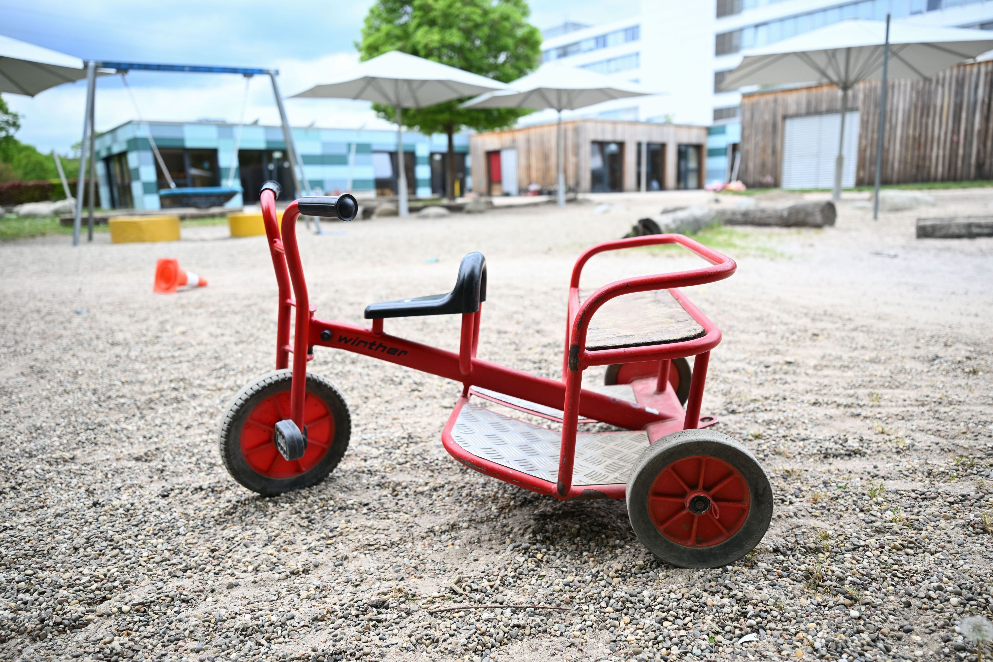 Spielgeräte stehen vor einer Kindertagesstätte.