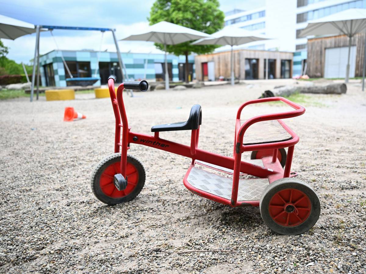 Spielgeräte stehen vor einer Kindertagesstätte.