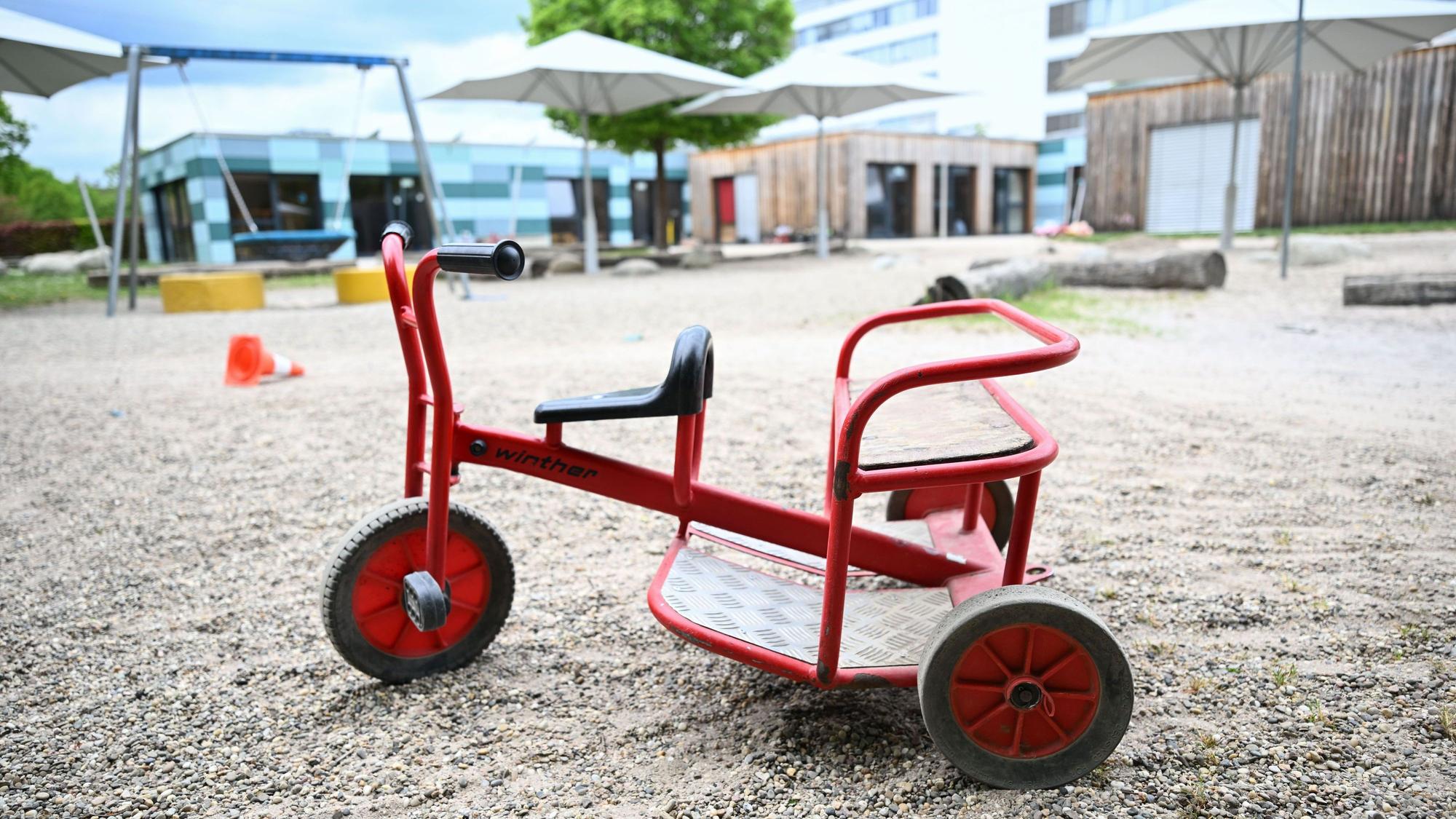Spielgeräte stehen vor einer Kindertagesstätte.
