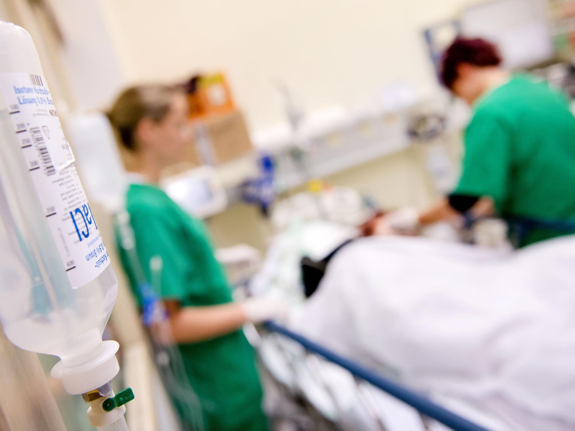 Medizinisches Personal versorgt in einem Krankenhaus einen Patienten. 30 Grad, 35 Grad, 40 Grad - unter der Rekordhitze litten die Patienten der rund 350 Krankenhäuser in NRW besonders. (Symbolfoto)