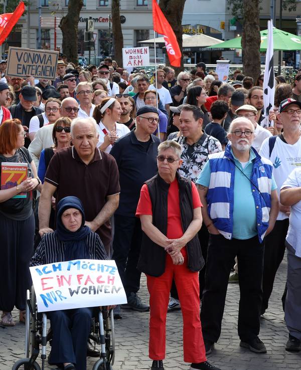 Zahlreiche Menschen nehmen an einer Kundgebung teil, eine Frau im Rollstuhl hält ein Plakat mit der Aufschrift „Ich möche einfach nur wohnen“.