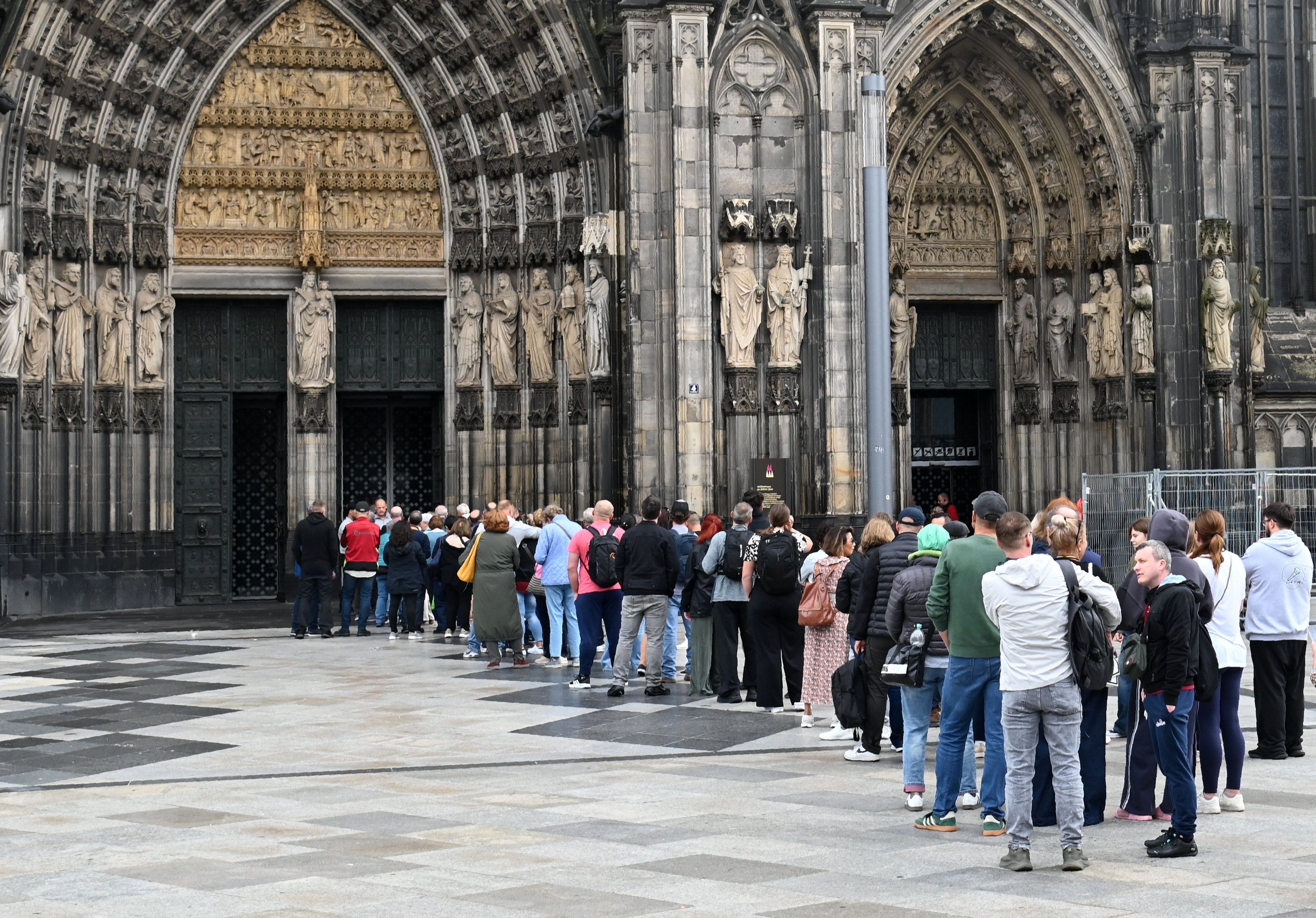 Besucher stehen Schlange am Haupteingang des Domes.