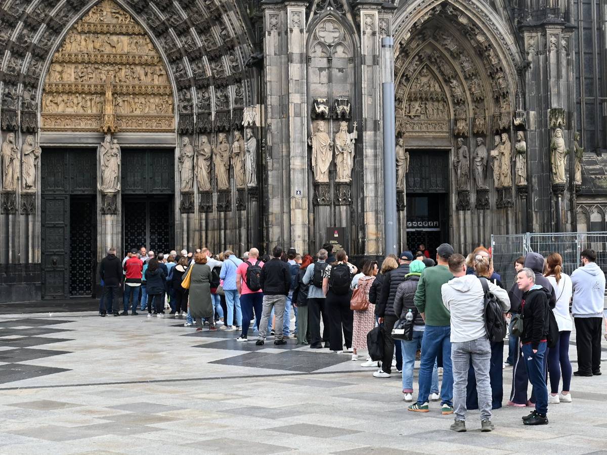 Besucher stehen Schlange am Haupteingang des Domes.