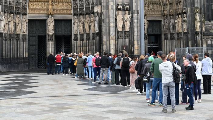 Besucher stehen Schlange am Haupteingang des Domes.