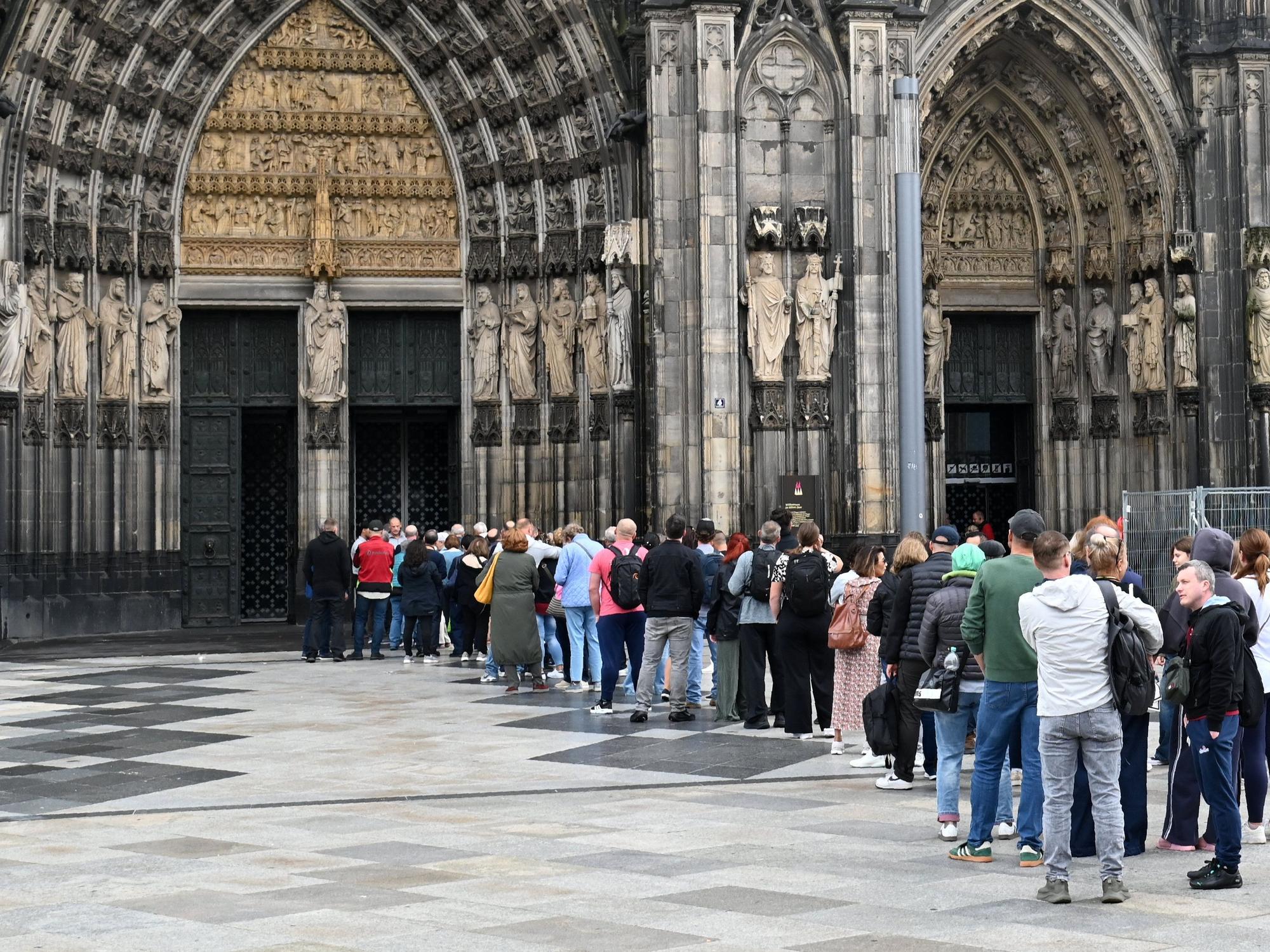 Besucher stehen Schlange am Haupteingang des Domes.