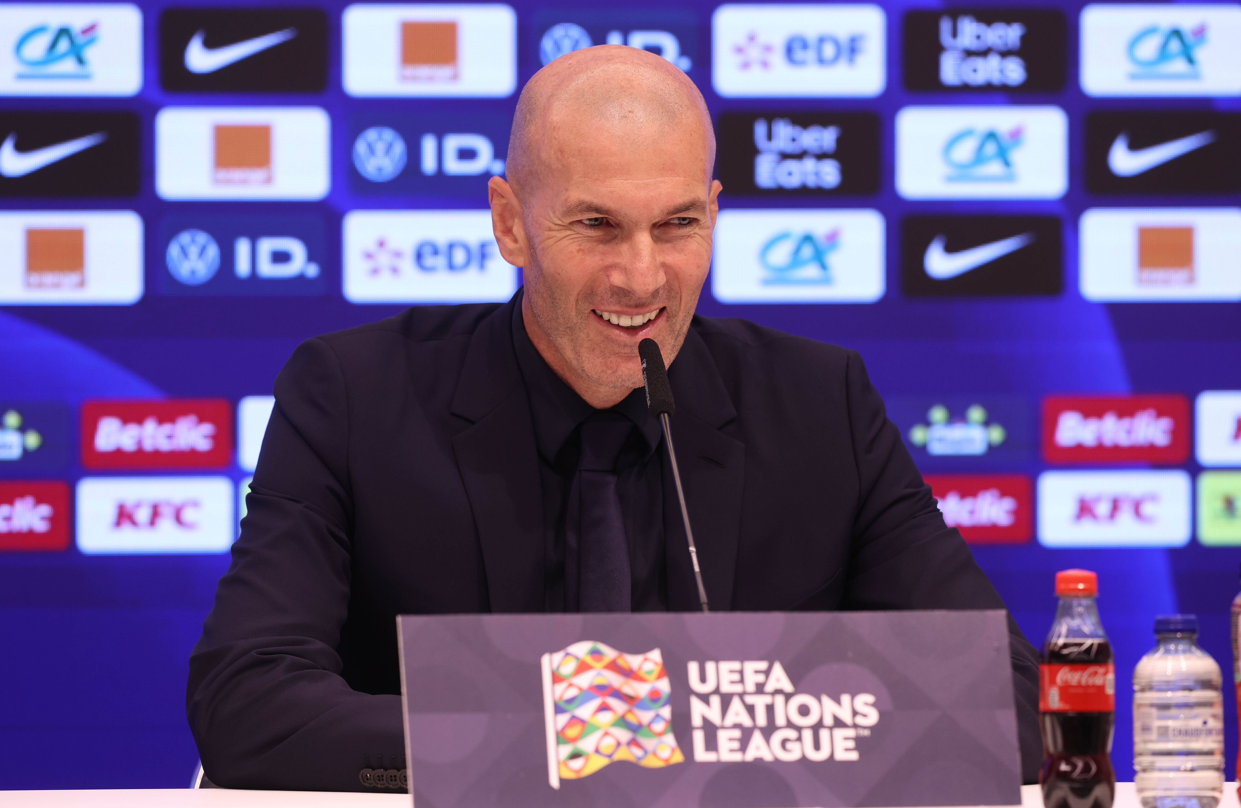 Zinedine Zidane lacht auf einer Pressekonferenz als französischer Nationaltrainer.