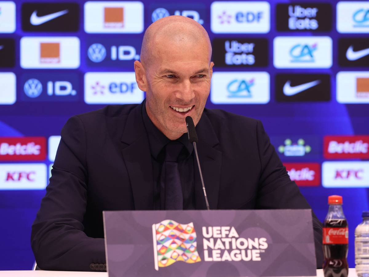 Zinedine Zidane lacht auf einer Pressekonferenz als französischer Nationaltrainer.