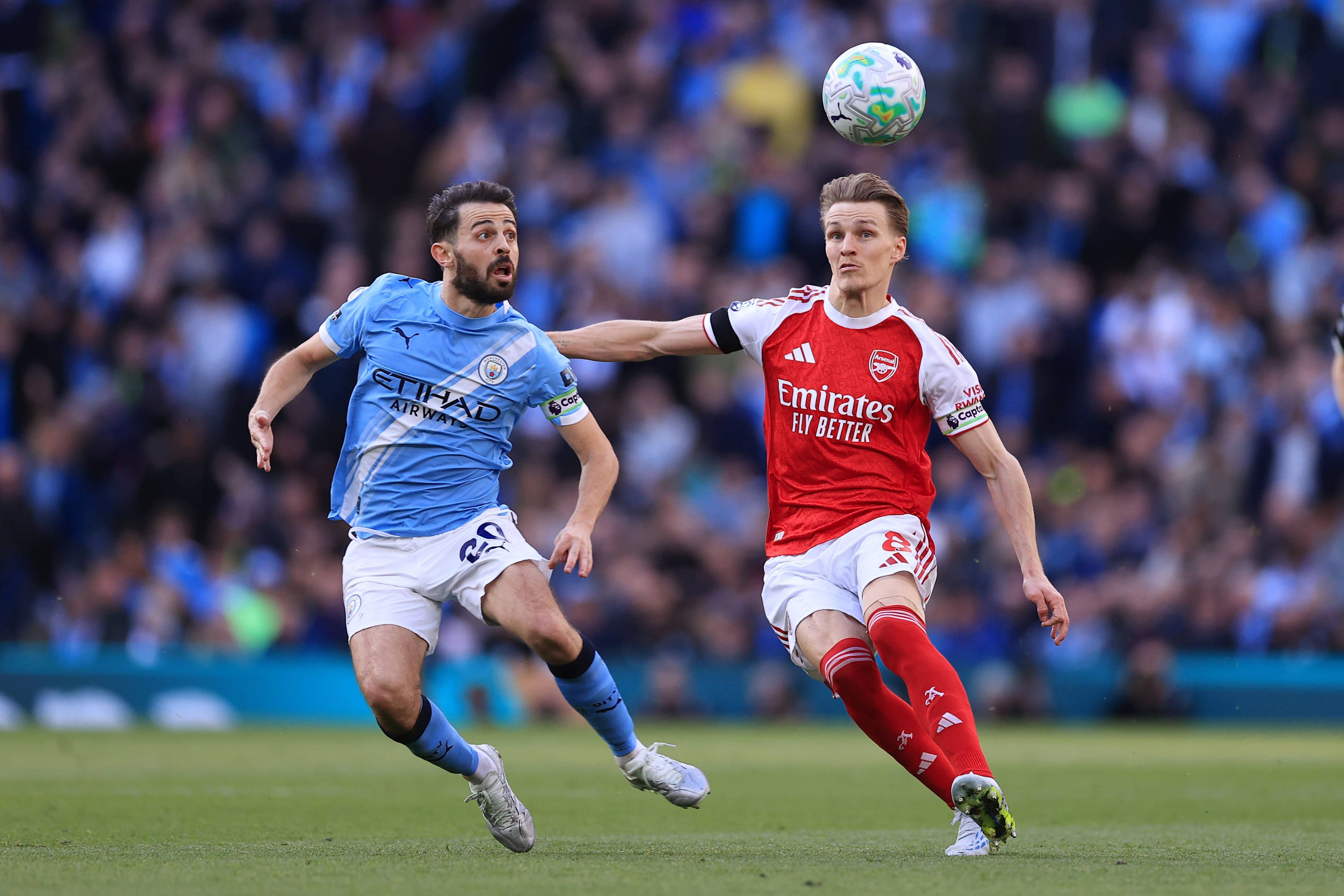 Martin Ödegaard und Bernardo Silva schauen auf den Ball in der Luft.