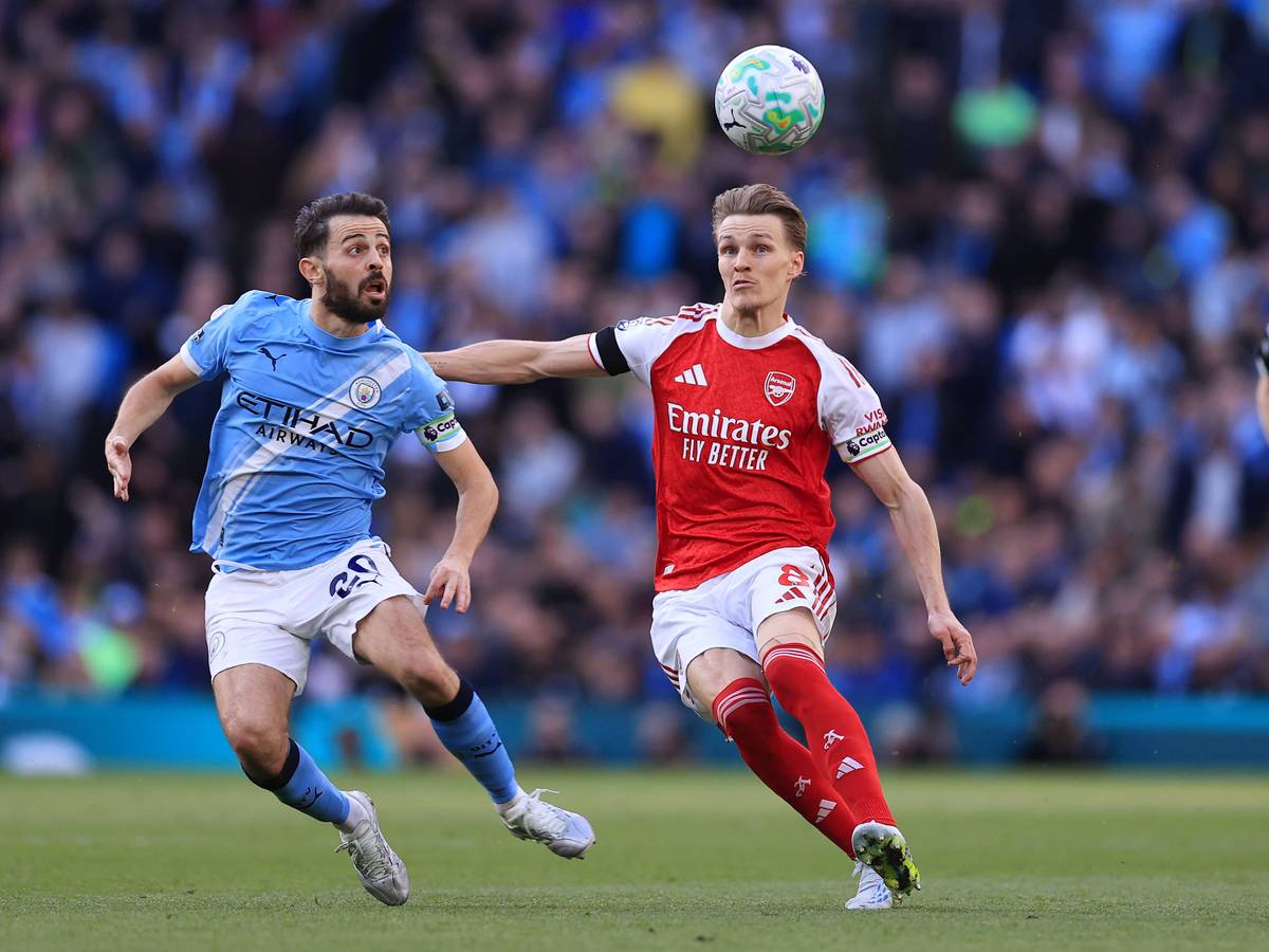 Martin Ödegaard und Bernardo Silva schauen auf den Ball in der Luft.