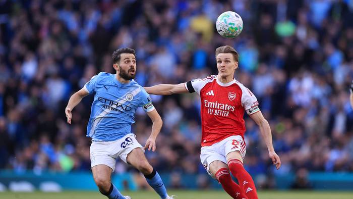 Martin Ödegaard und Bernardo Silva schauen auf den Ball in der Luft.