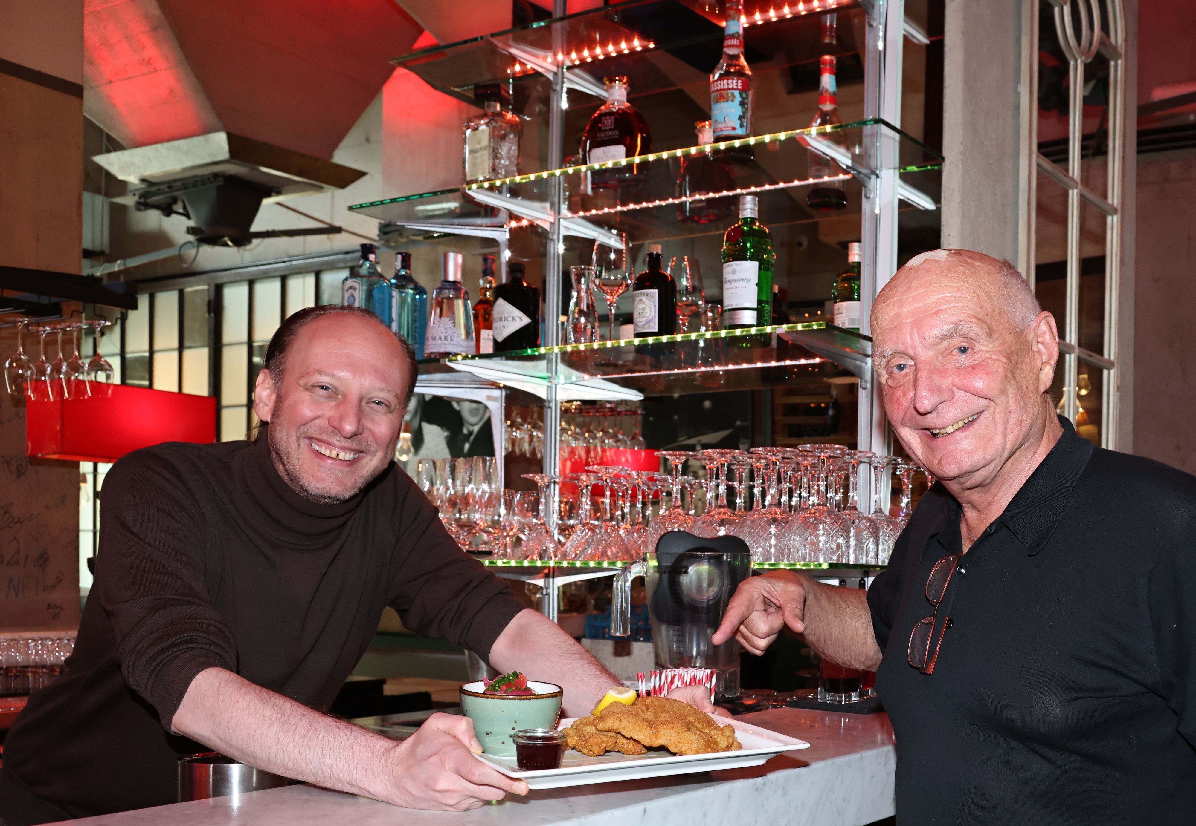 Torsten Schliesing serviert Inhaber Dr. Rudolf von Borries ein Schnitzel.