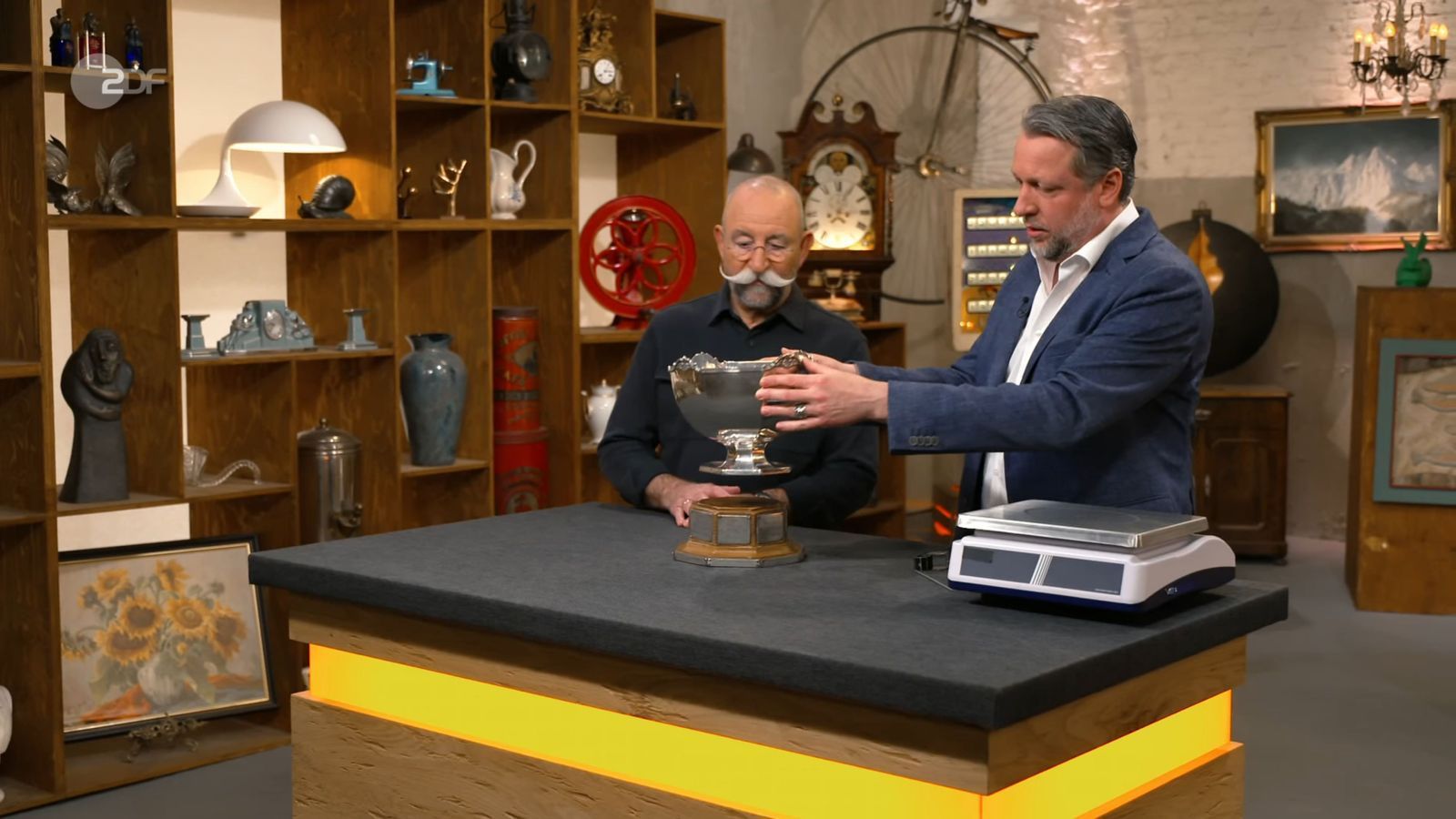 „Das ist aber mal sehr schön!“, begeisterte sich Horst Lichter (lichts) für einen Pokal, der am Dienstag bei „Bares für Rares“ angeboten wurde. (Bild: ZDF)