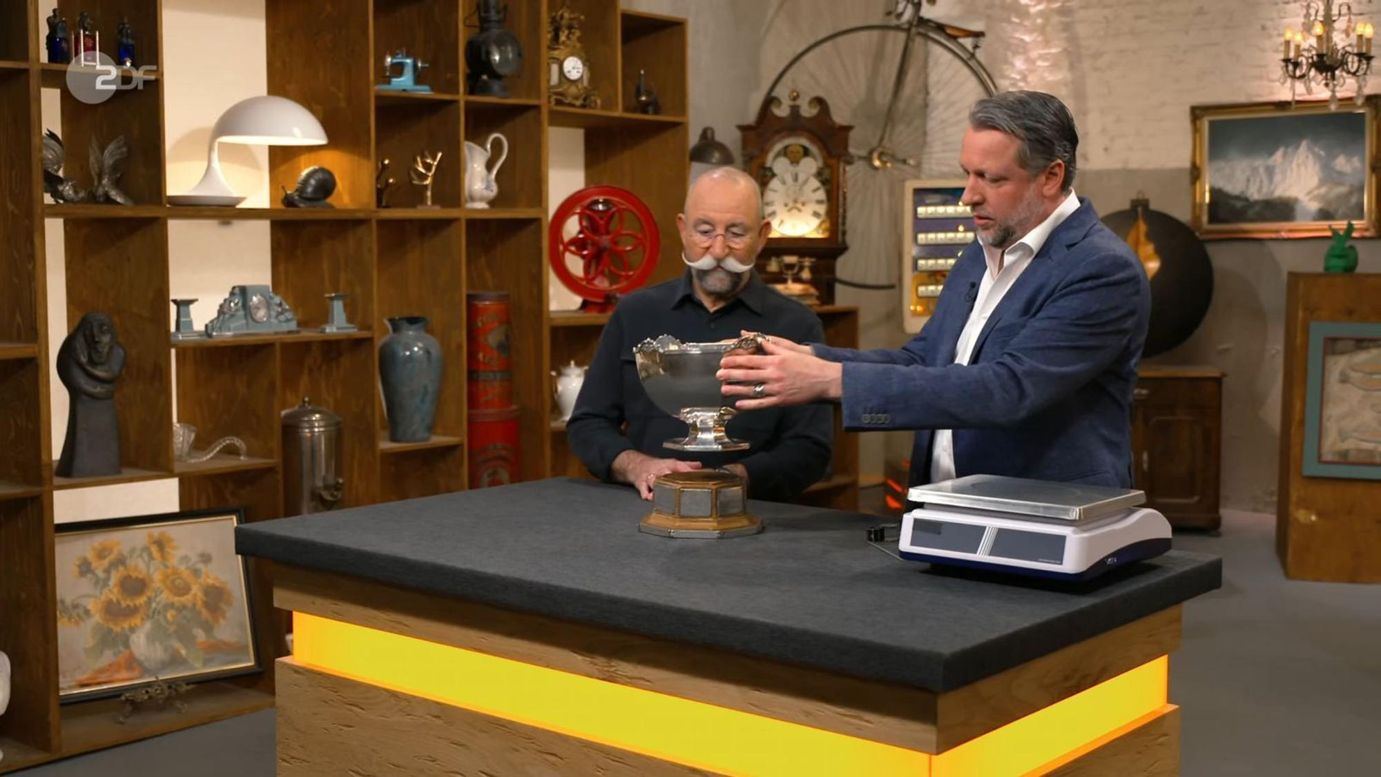 „Das ist aber mal sehr schön!“, begeisterte sich Horst Lichter (lichts) für einen Pokal, der am Dienstag bei „Bares für Rares“ angeboten wurde. (Bild: ZDF)
