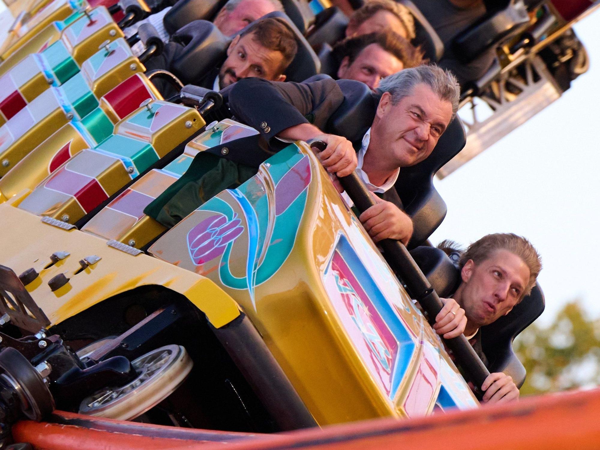 Bayerns Ministerpräsident Markus Söder (CSU, links) und Dominik Krause (Grüne), Oberbürgermeister von München, fahren anlässlich der Nominierung Münchens als deutscher Olympia-Bewerber auf dem Oktoberfest zusammen mit der Achterbahn „Olympia Looping“.