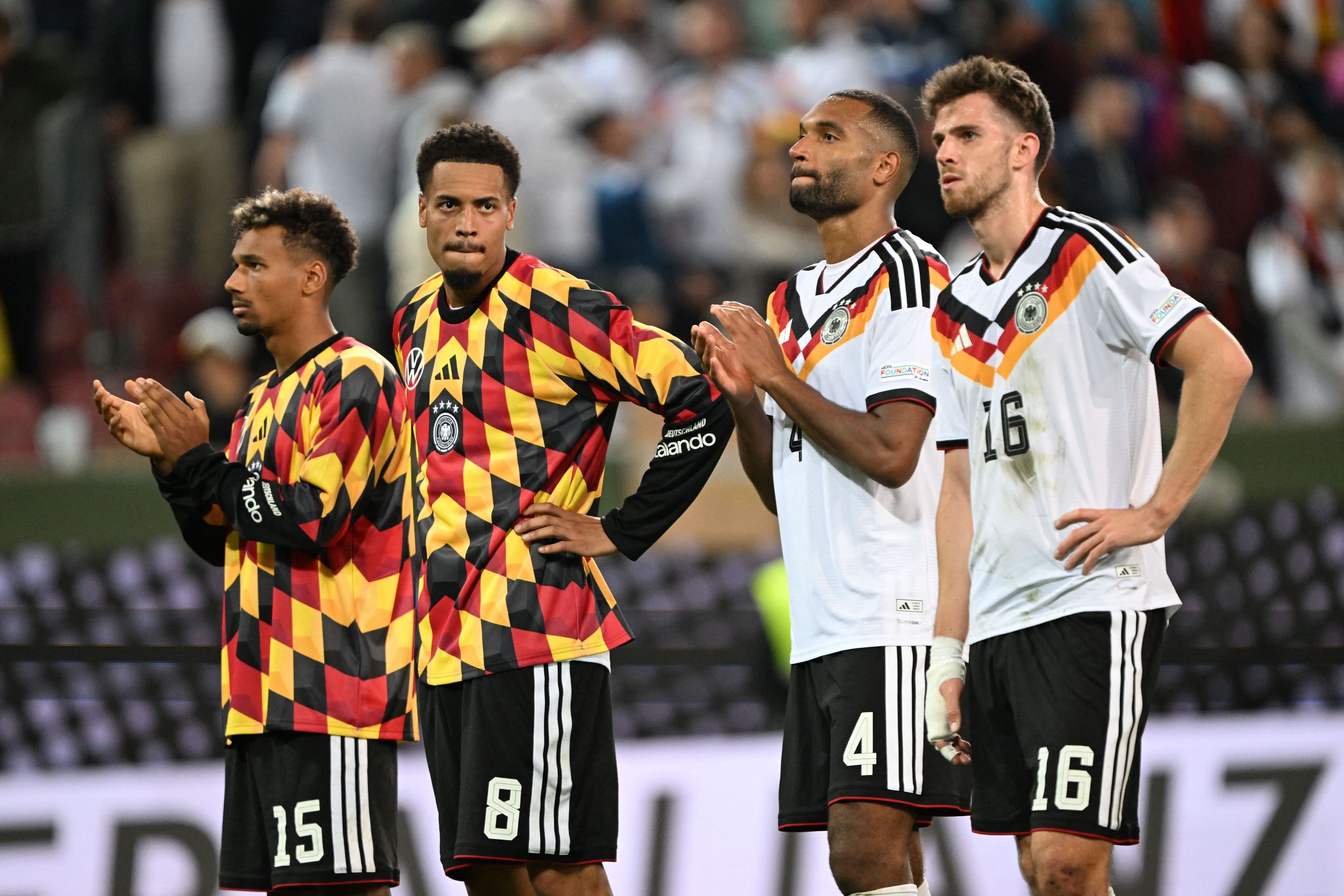 Bambasé Conté, Felix Nmecha, Jonathan Tah und Anton Stach stehen enttäuscht vor den Fans.