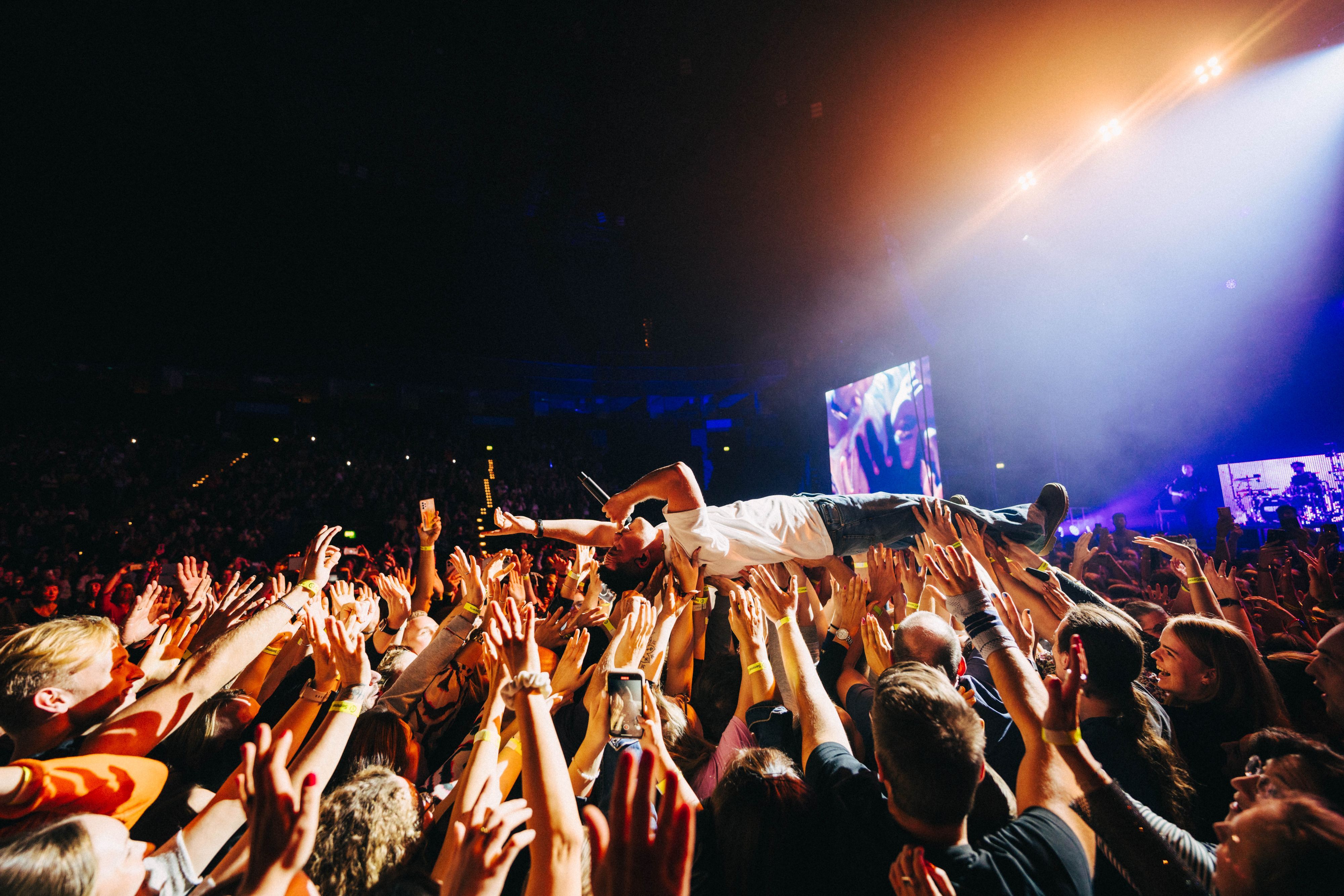 Nico Santos beim Crowdsurfen - er wird von Fans auf den Händen durch den Konzertsaal "weitergereicht"