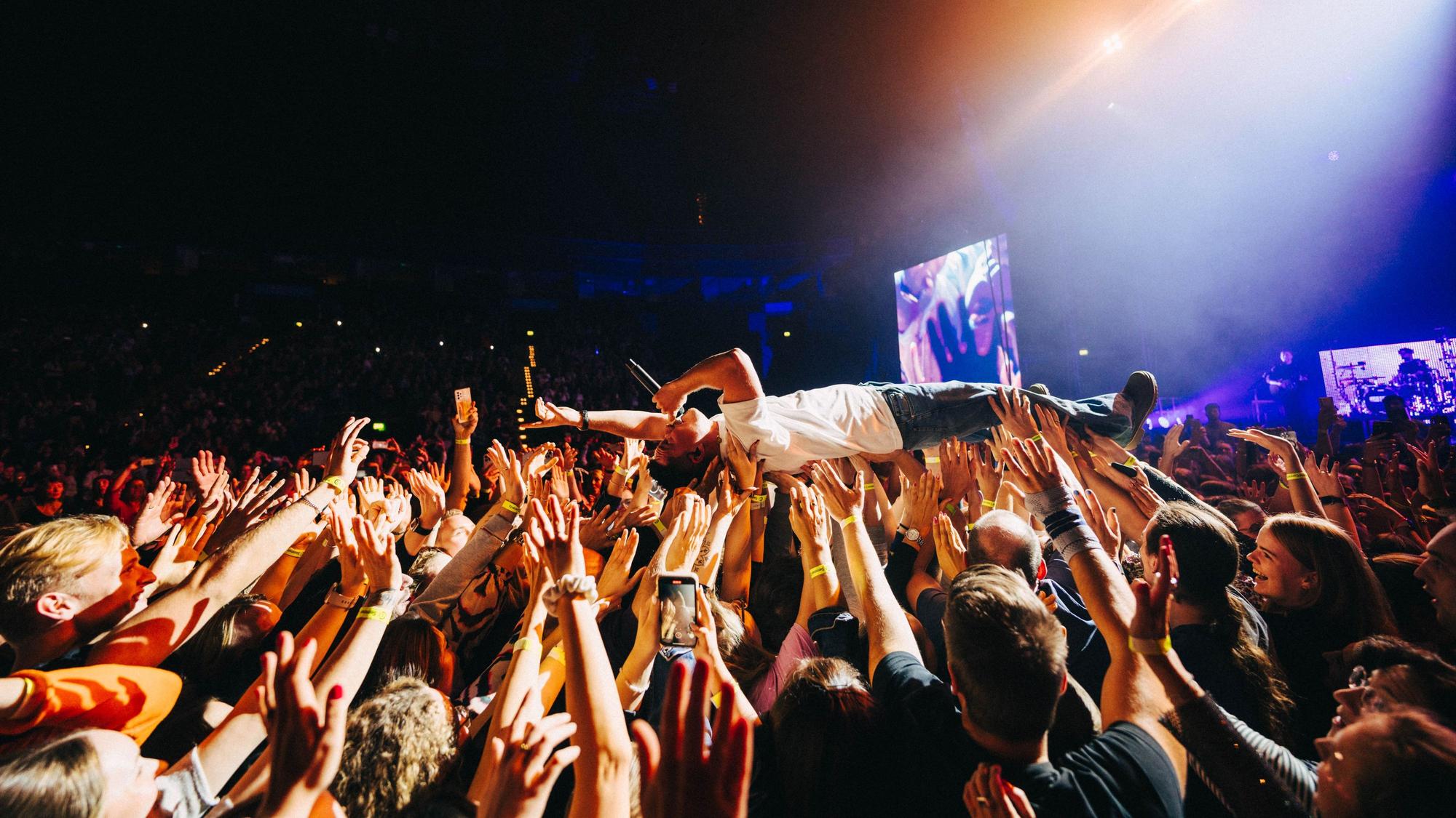 Nico Santos beim Crowdsurfen - er wird von Fans auf den Händen durch den Konzertsaal "weitergereicht"