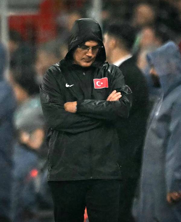 Vincenzo Montella steht mit verschränkten Armen, gesenktem Kopf und einer Regenjacke am Seitenrand.
