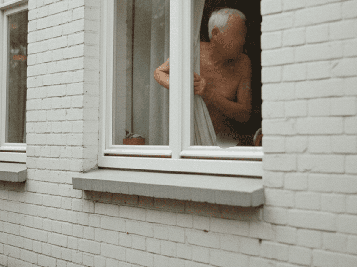 Das maschinell erzeugte Symbolbild zeigt einen älteren Herren, der durch ein Fenster schaut. Elf Jahre lang wurde eine Witwe in England von ihrem Nachbarn belästigt.