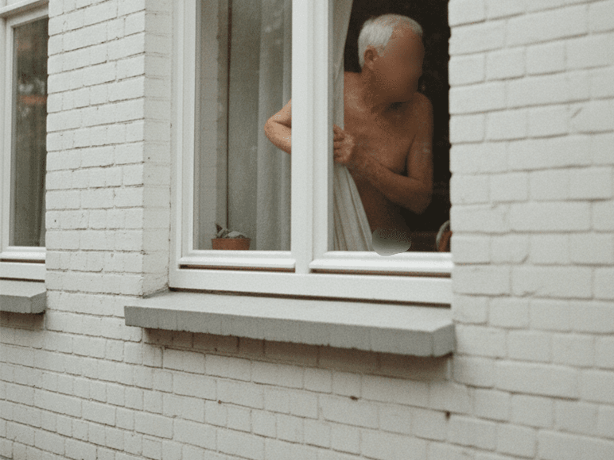 Das maschinell erzeugte Symbolbild zeigt einen älteren Herren, der durch ein Fenster schaut. Elf Jahre lang wurde eine Witwe in England von ihrem Nachbarn belästigt.