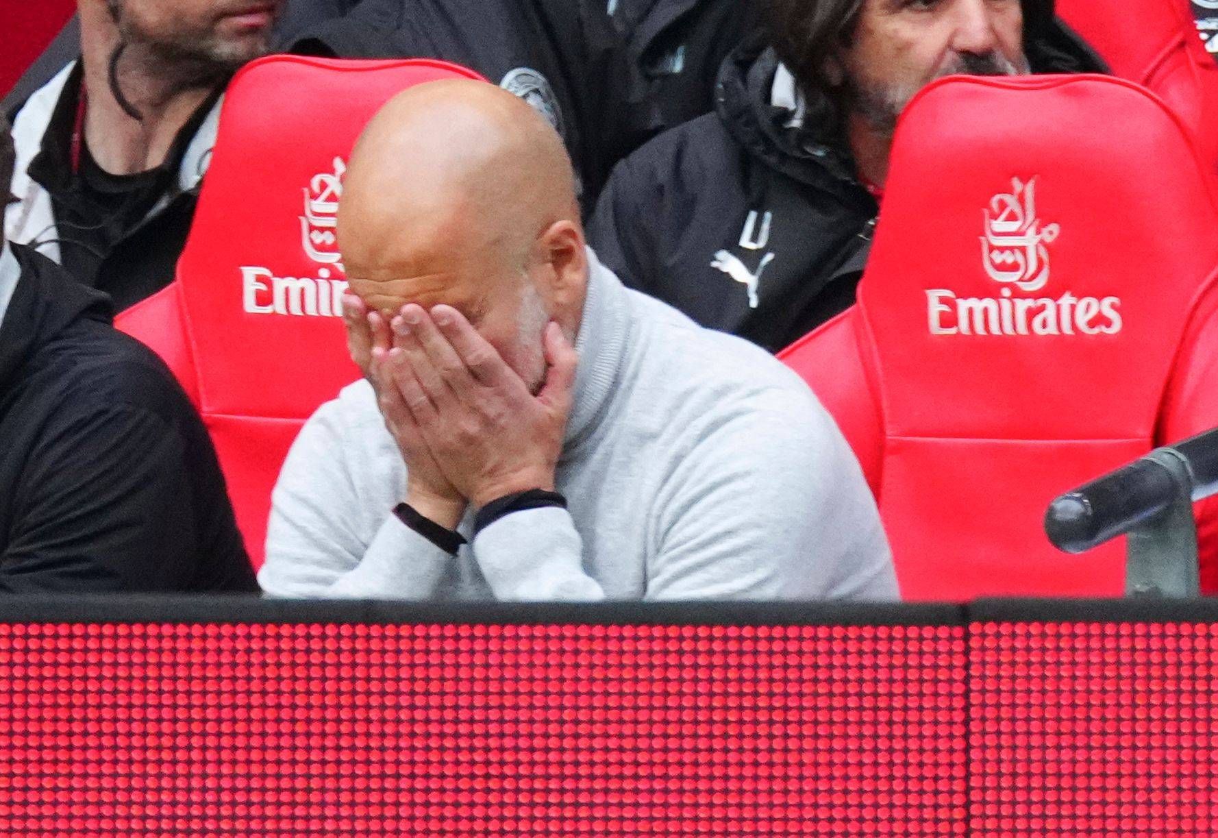 Pep Guardiola vergräbt sein Gesicht in seinen Händen.