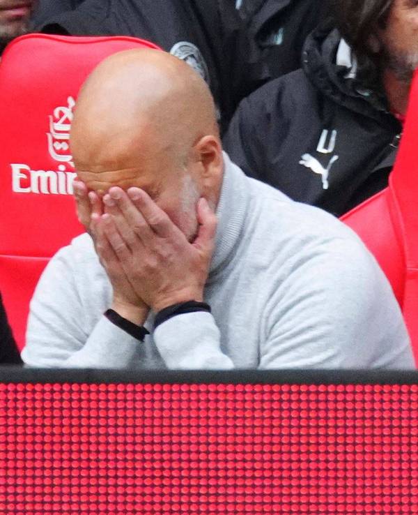 Pep Guardiola vergräbt sein Gesicht in seinen Händen.