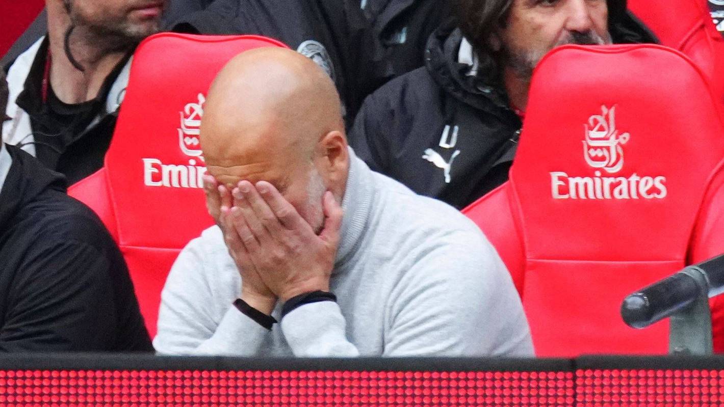 Pep Guardiola vergräbt sein Gesicht in seinen Händen.