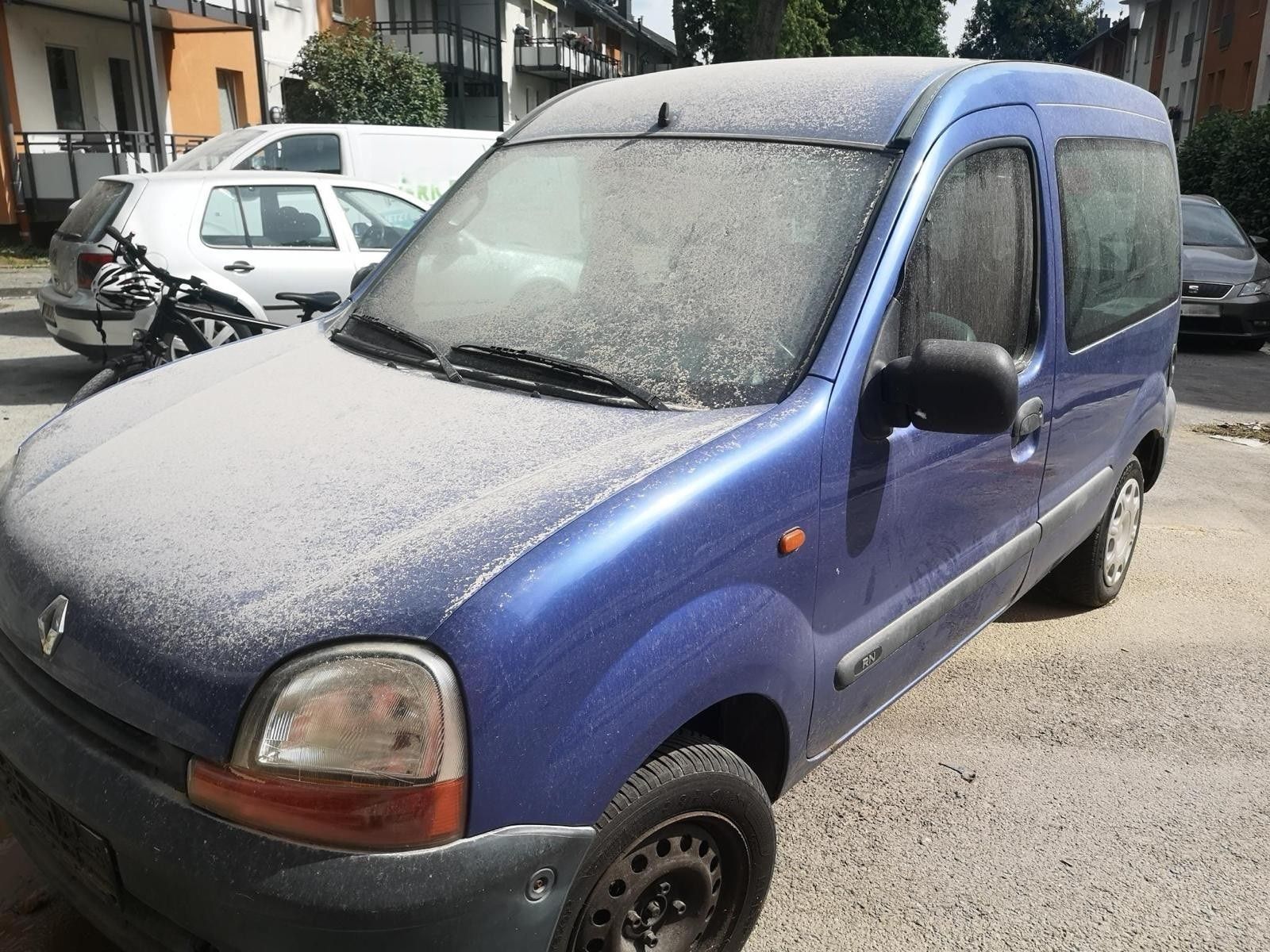 Auf einem Auto, das nahe der Abrissstelle steht, liegt eine Staubschicht.