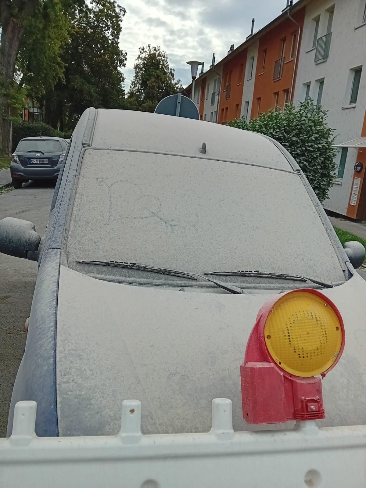 Ein Auto ist komplett mit Staub bedeckt.