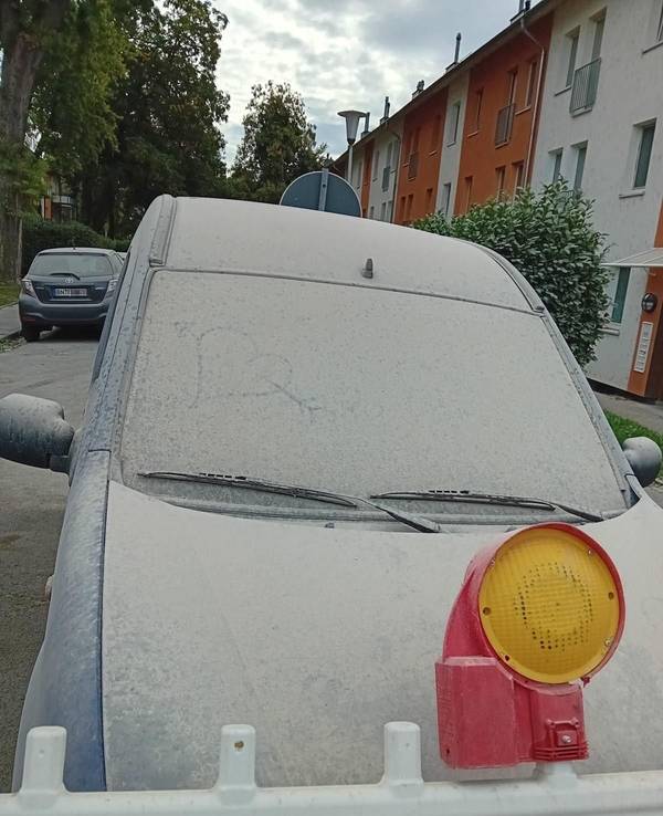 Ein Auto ist komplett mit Staub bedeckt.