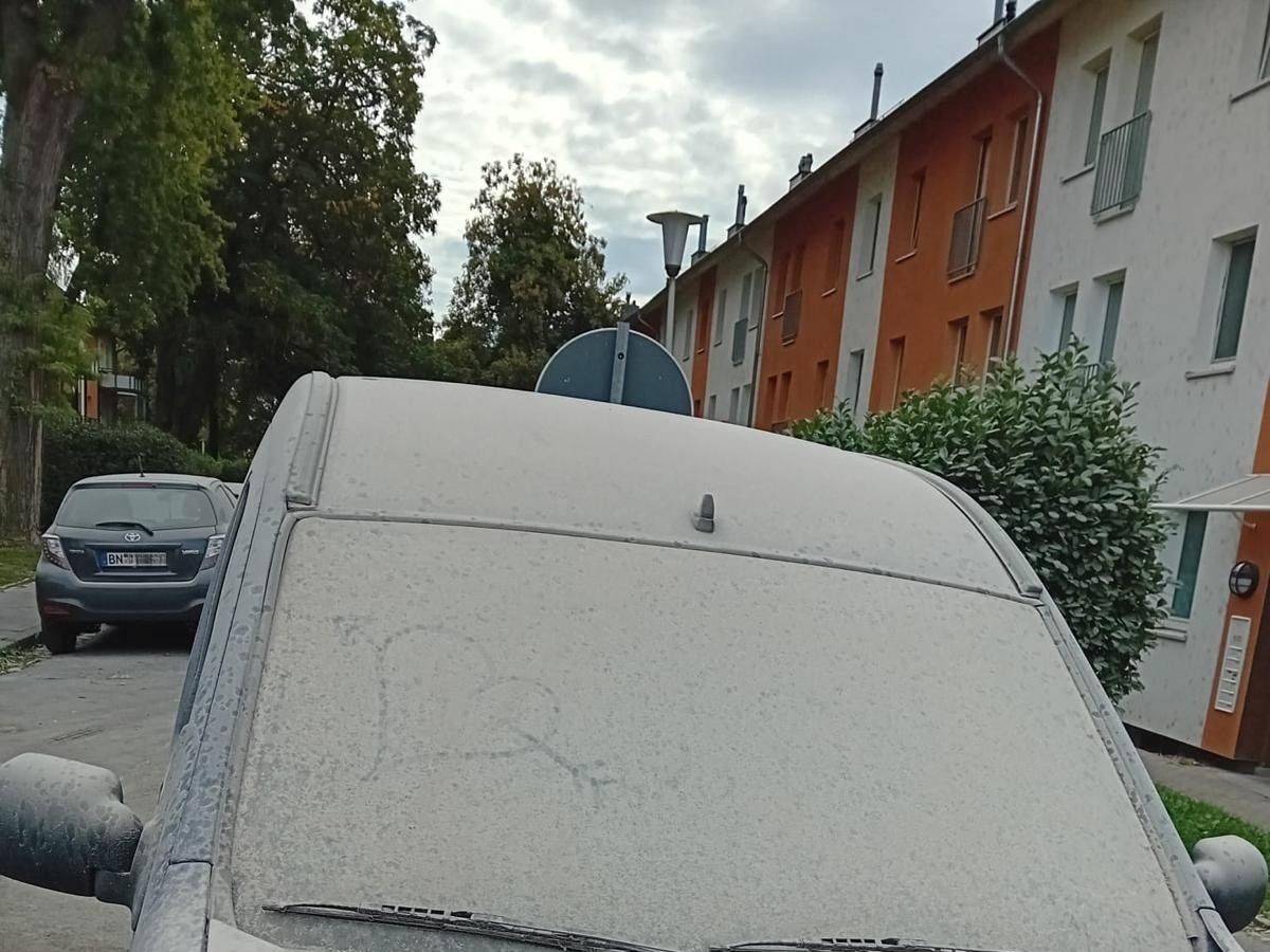 Ein Auto ist komplett mit Staub bedeckt.