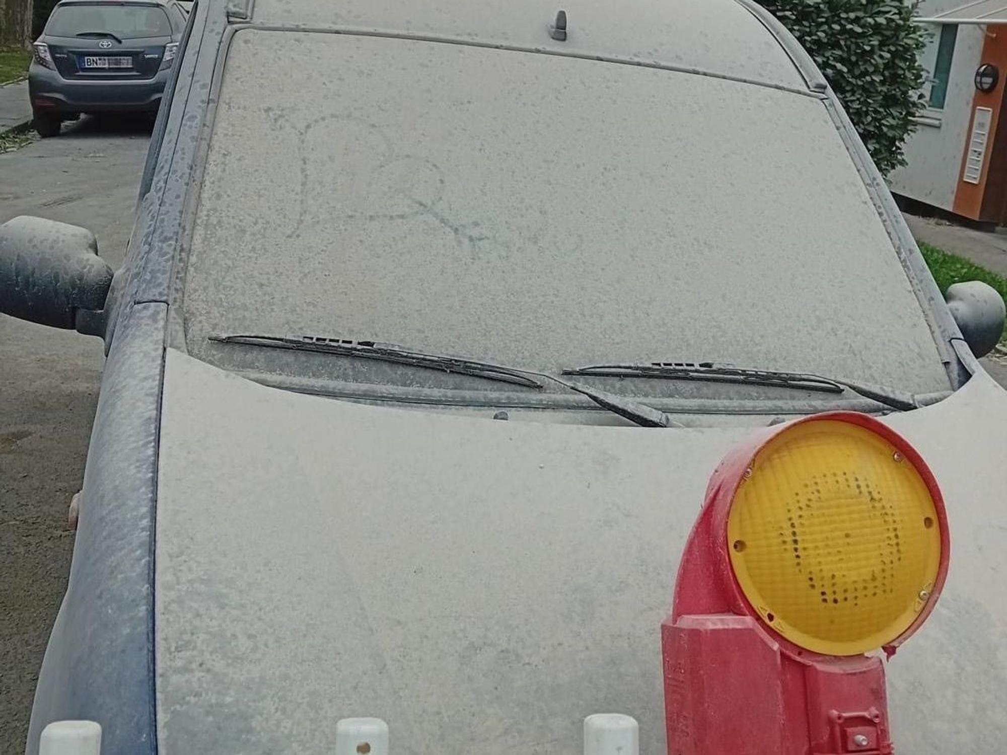 Ein Auto ist komplett mit Staub bedeckt.