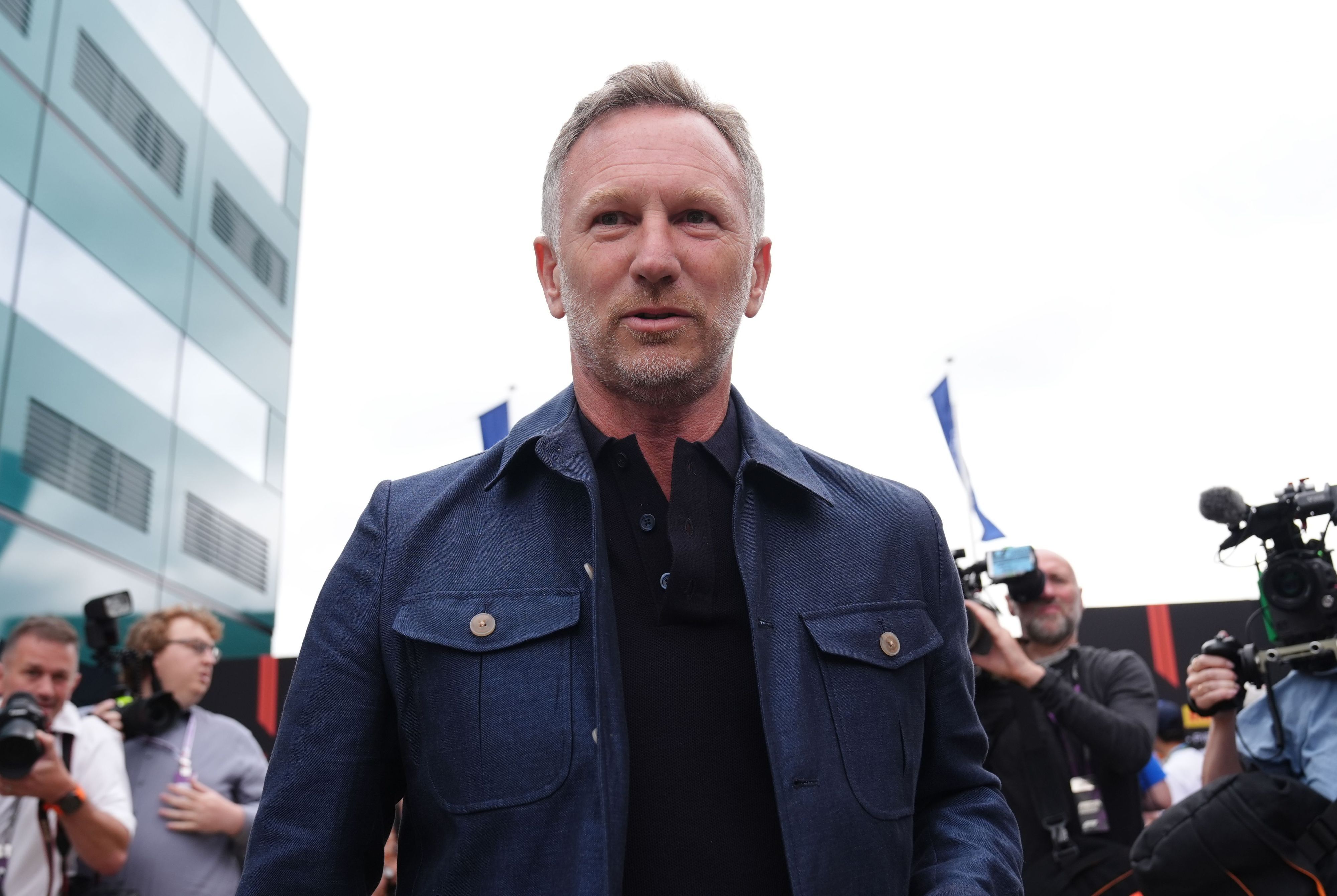 Christian Horner im Fahrerlager, hinter ihm sind Kameraleute.