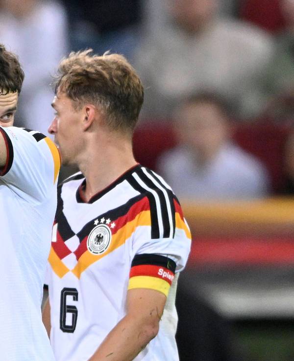Florian Wirtz wischt sich mit seinem Arm durch das Gesicht, Joshua Kimmich schaut ihn an.